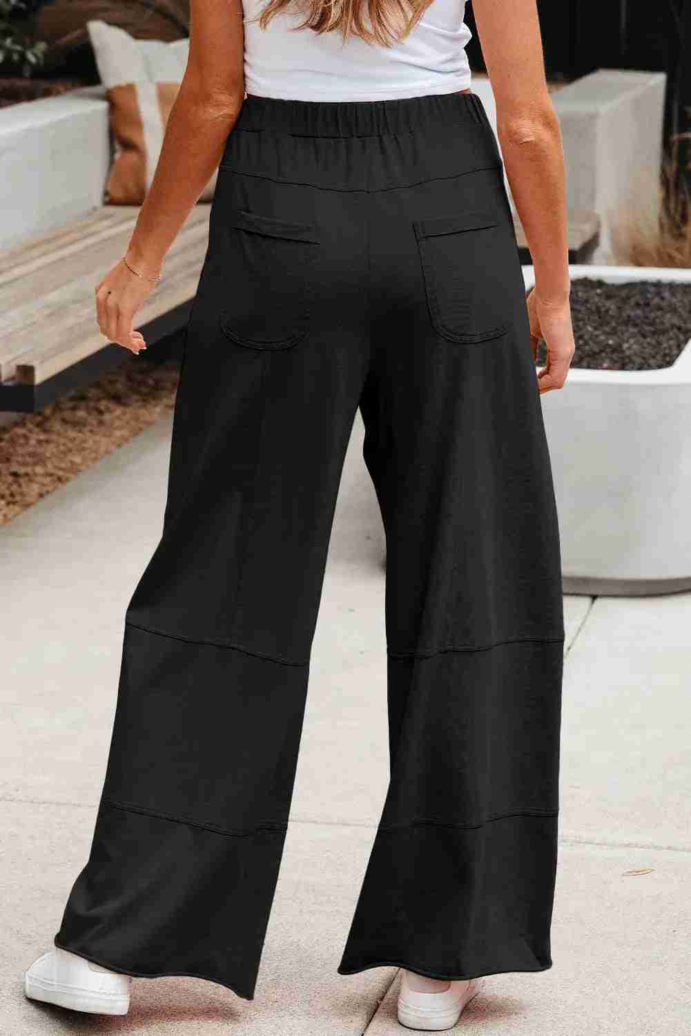 Pantalon cargo femme noir à jambes larges, taille élastique, poches plaquées sur le devant