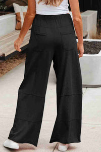 Pantalon cargo femme noir à jambes larges, taille élastique, poches plaquées sur le devant