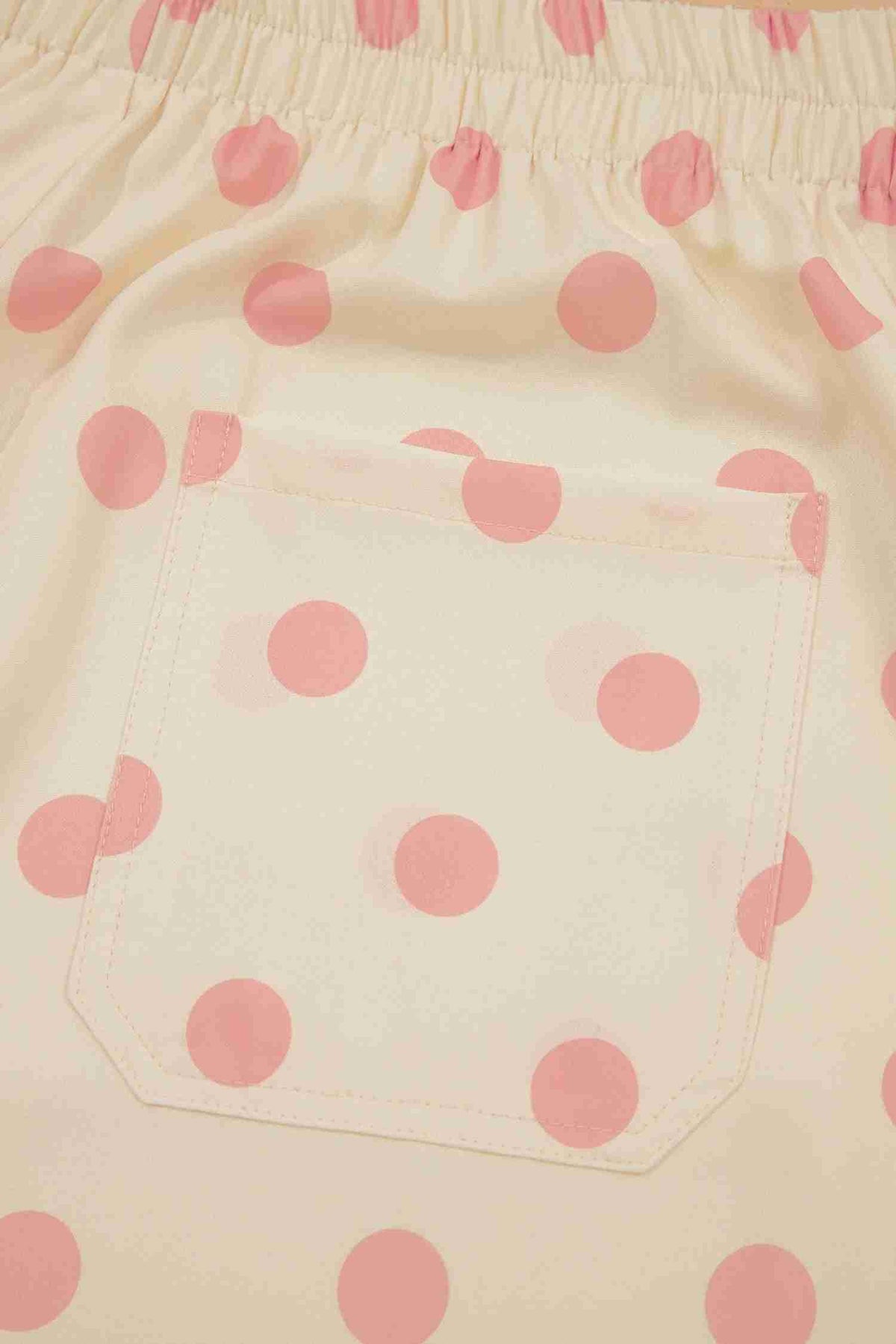Poche arrière du pantalon blanc à pois roses, surpiqûres visibles