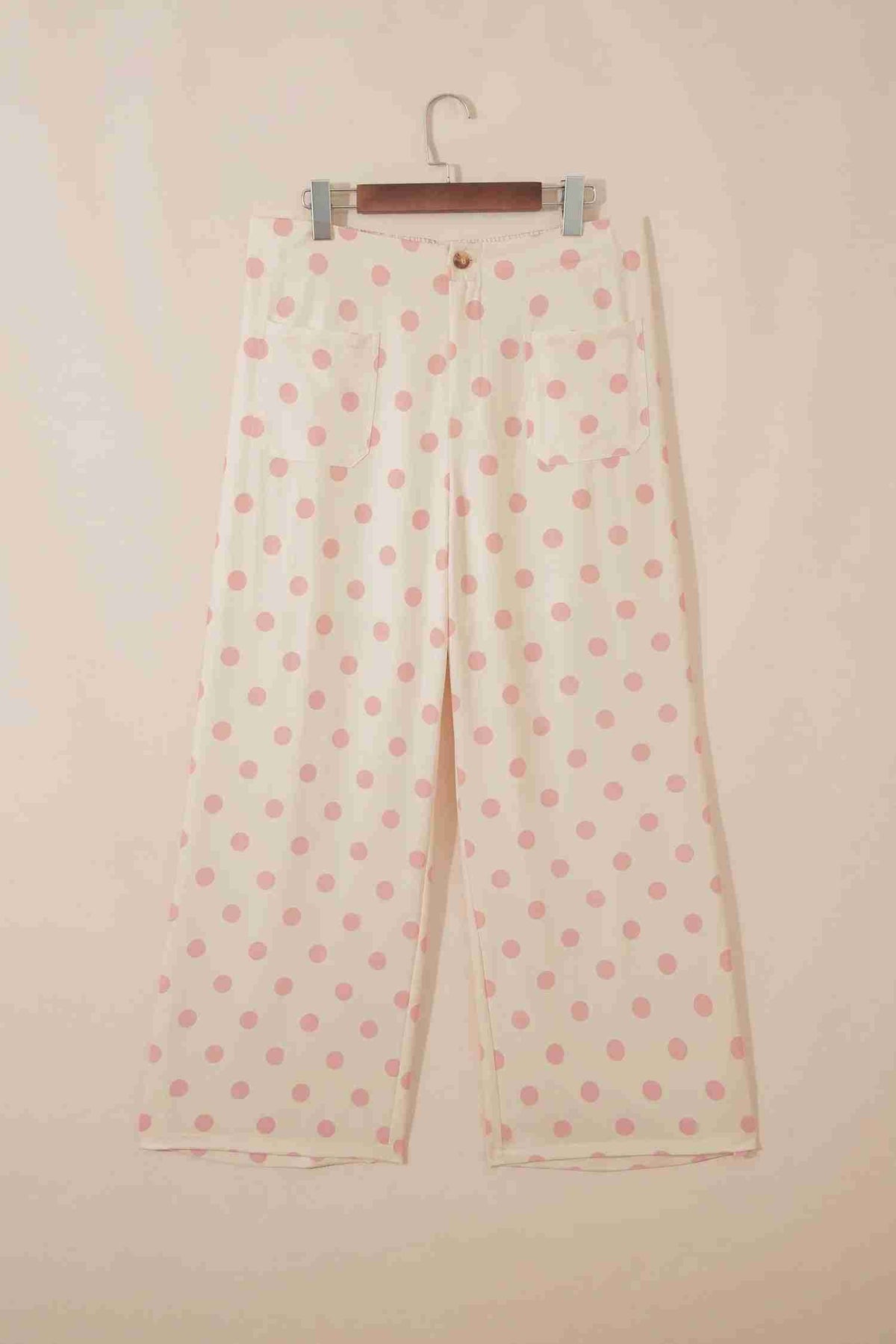 Pantalon blanc à pois roses sur cintre, coupe droite et taille mi-haute