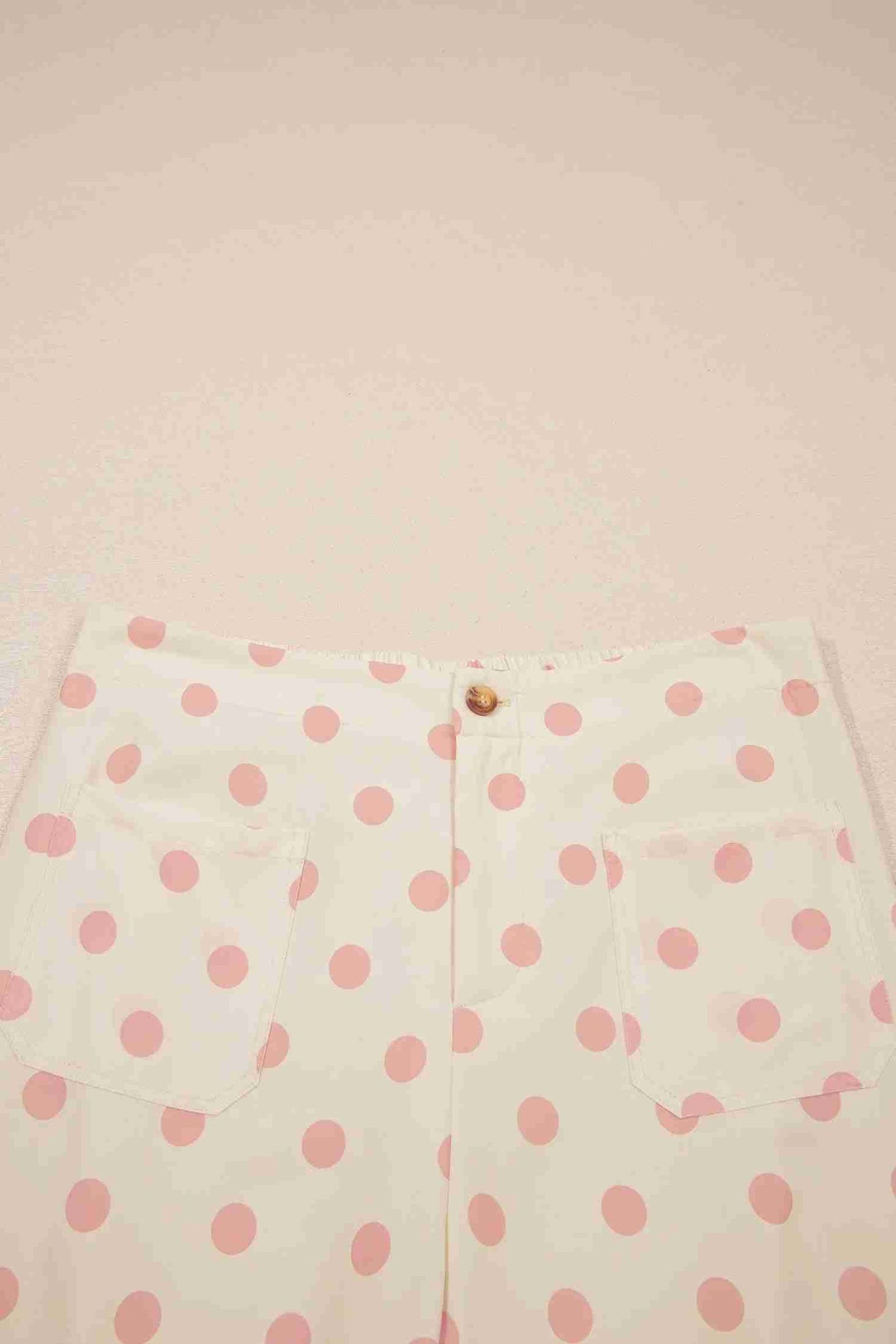 Boutonnage et fermeture du pantalon blanc à pois roses, taille mi-haute