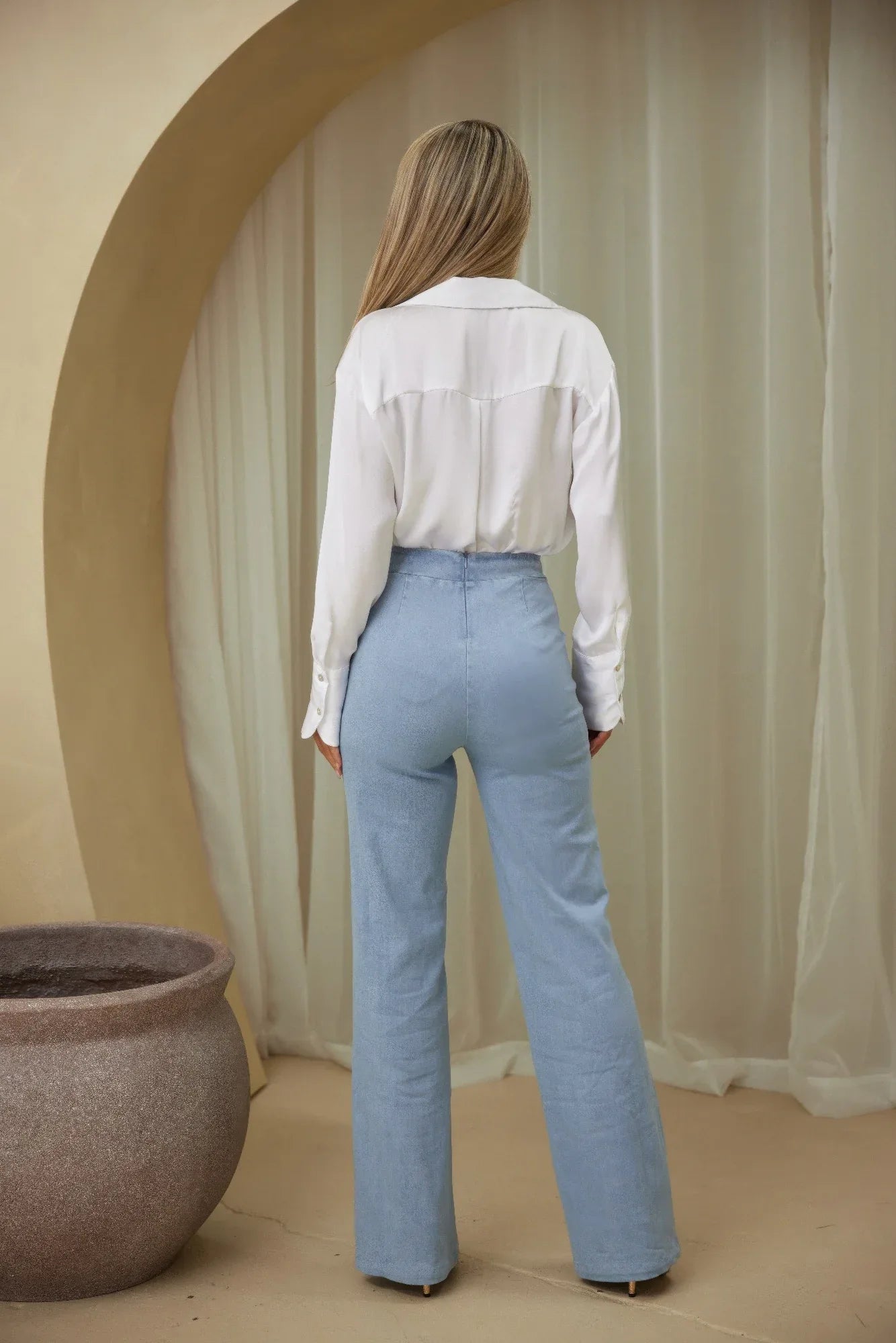 Pantalon flare bleu clair, vue de dos, taille haute et jambe évasée.