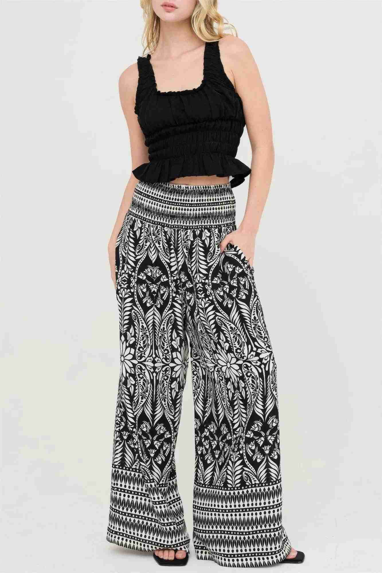 Pantalon long ample noir et blanc à motif fleuri, taille smockée élastique.