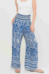 Pantalon fluide bleu à motif fleuri, taille smockée et coupe ample évasée
