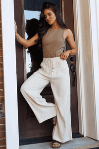 Pantalon large femme écru avec lien à la taille élastique et patte boutonnée