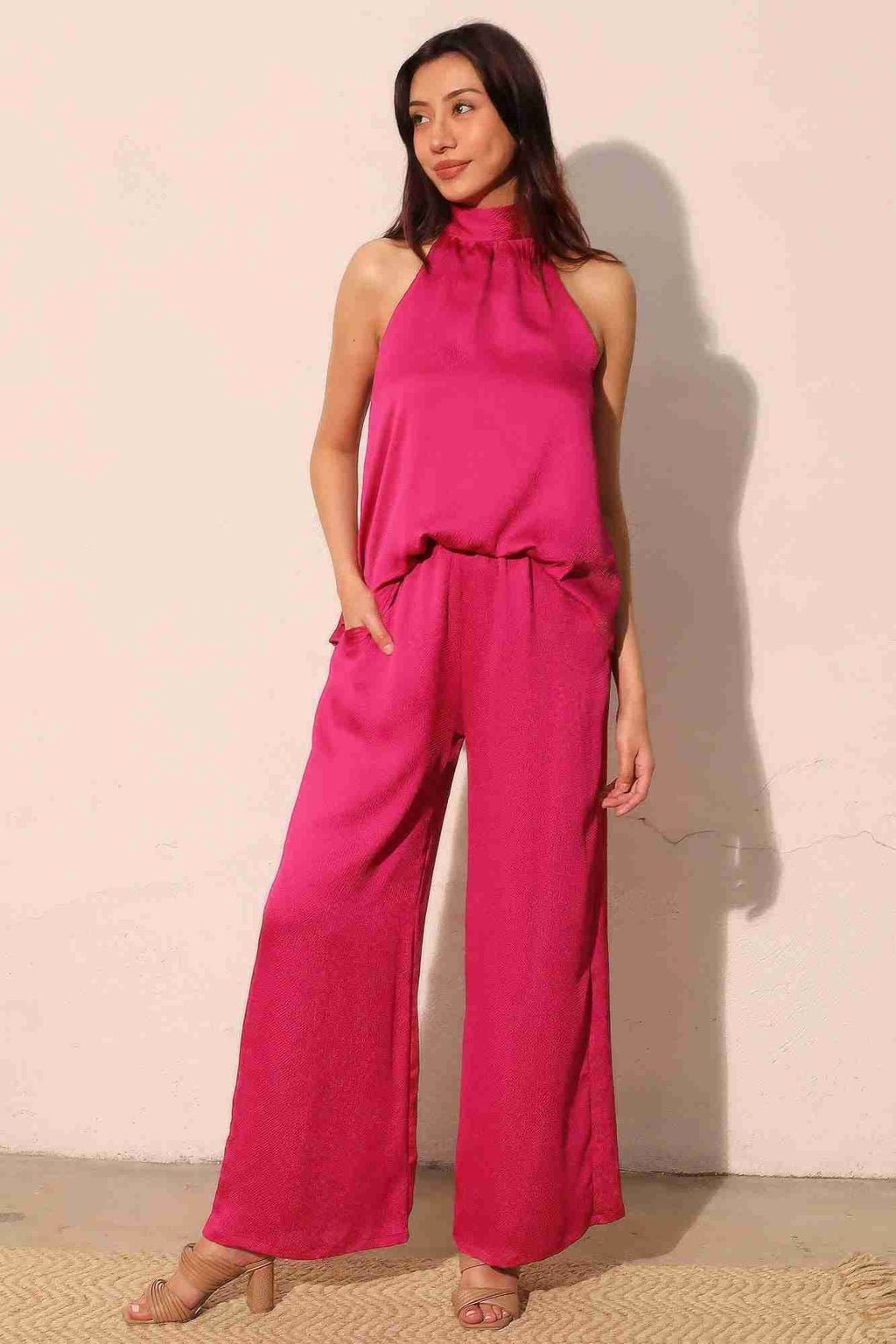 Pantalon satiné fluide fuchsia, taille élastique haute, jambe ample, poches visibles.