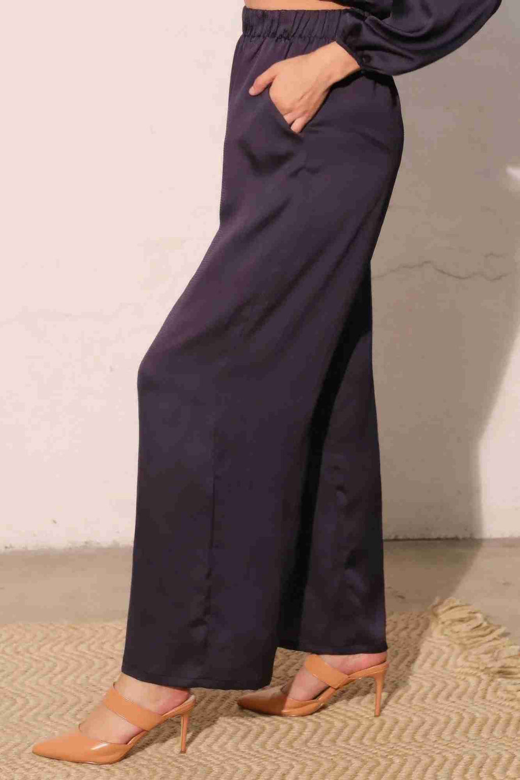 Pantalon satiné fluide marine foncé, vue de profil, taille élastique, jambe large.