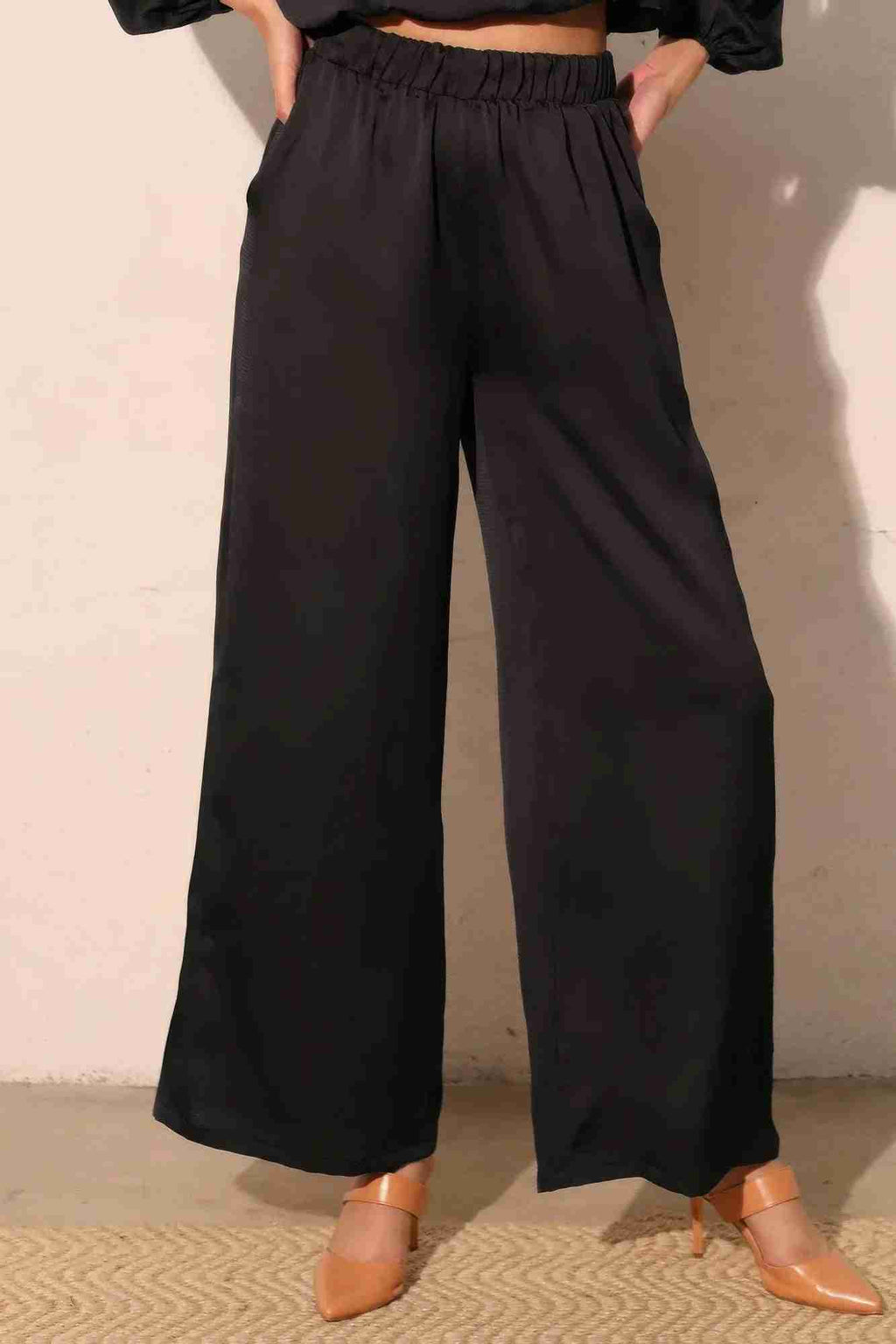 Pantalon satiné fluide marine foncé, vue de dos, taille élastique, jambes amples.