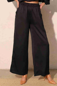 Pantalon satiné fluide marine foncé, vue de dos, taille élastique, jambes amples.