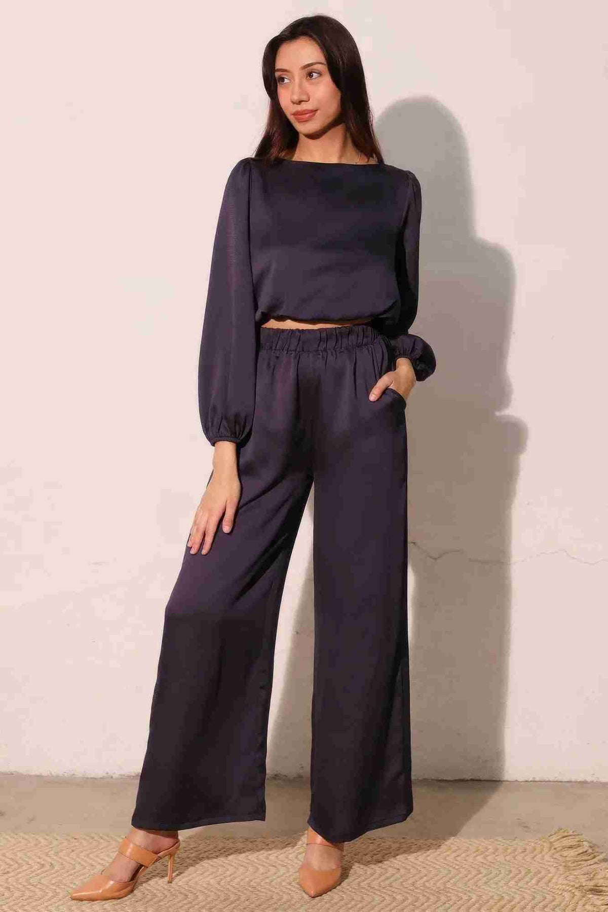 Pantalon satiné fluide marine foncé, taille élastique, jambe ample, poches latérales.