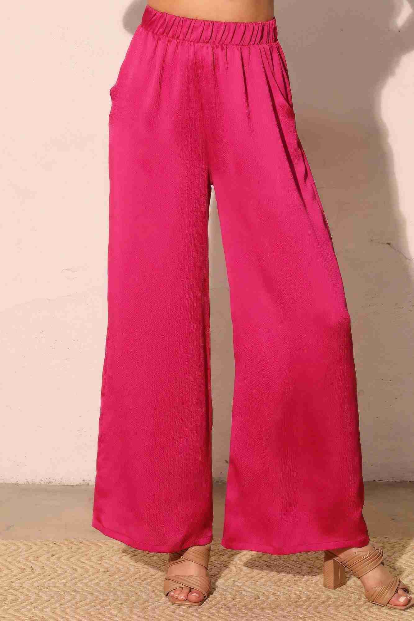 Pantalon satiné fluide fuchsia, taille élastique, jambes larges, poches latérales.