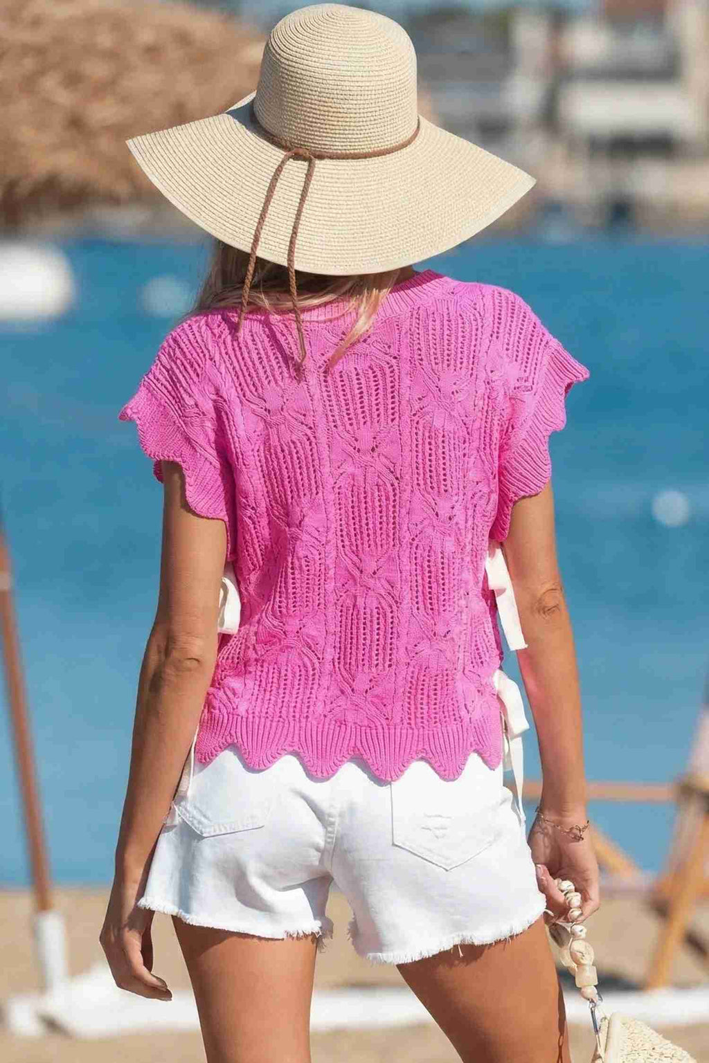Pull tricot pointelle rose vif, encolure ronde, manches courtes, bord festonné