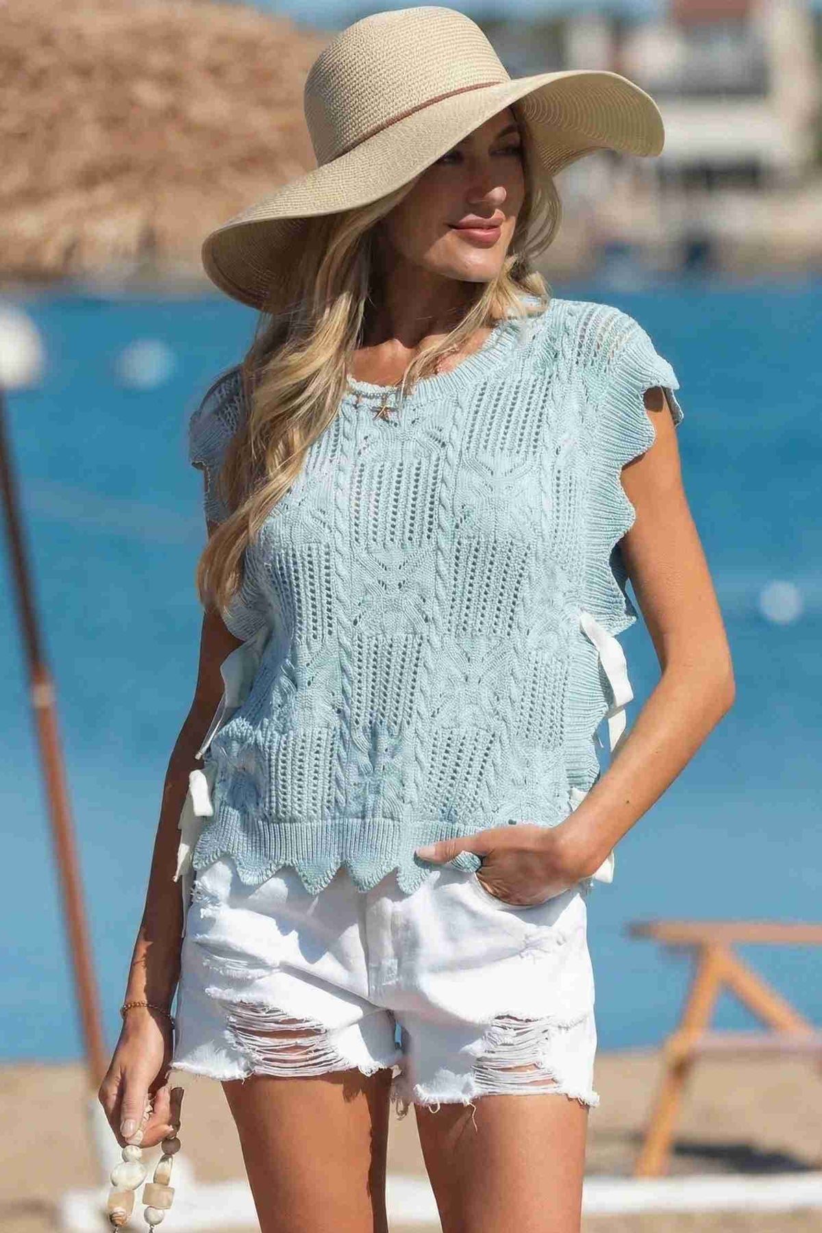Pull femme en tricot pointelle vert menthe, manches courtes et bord festonné