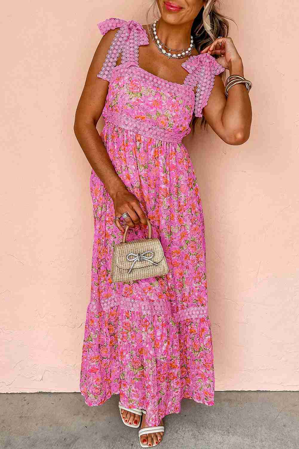 Robe longue rose à motif floral, bretelles à volants et encolure carrée.