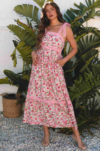 Robe longue rose à motif floral, bretelles à volants et encolure carrée en dentelle.