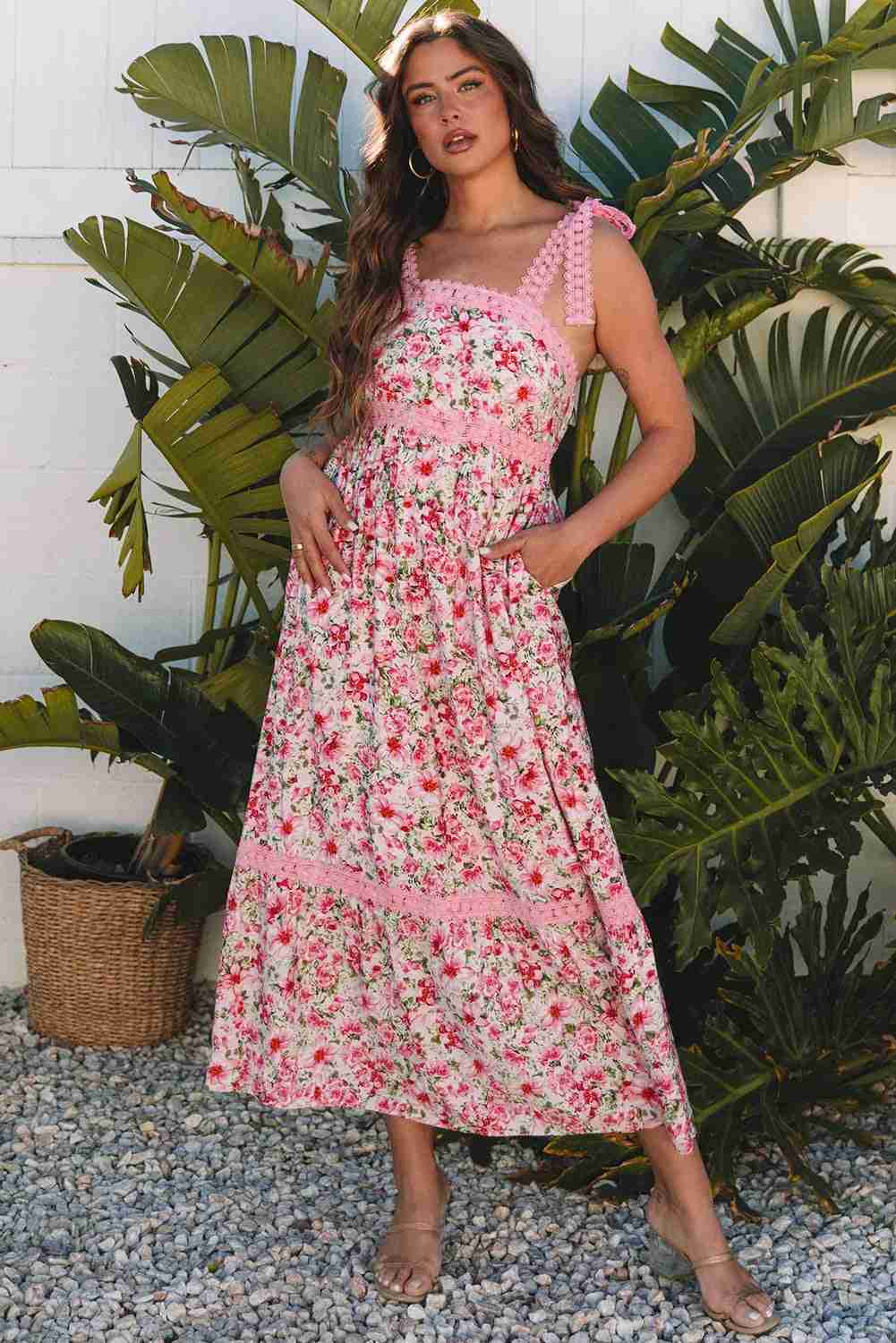 Robe longue rose à motif floral, bretelles à volants et encolure carrée en dentelle.