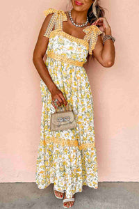 Robe longue crème à fleurs jaunes, bretelles à volants et encolure carrée.