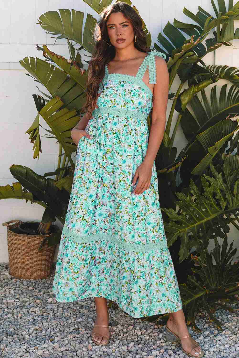 Robe longue turquoise à motif floral, bretelles festonnées et encolure carrée en dentelle.