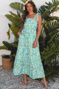 Robe longue turquoise à motif floral, bretelles festonnées et encolure carrée en dentelle.