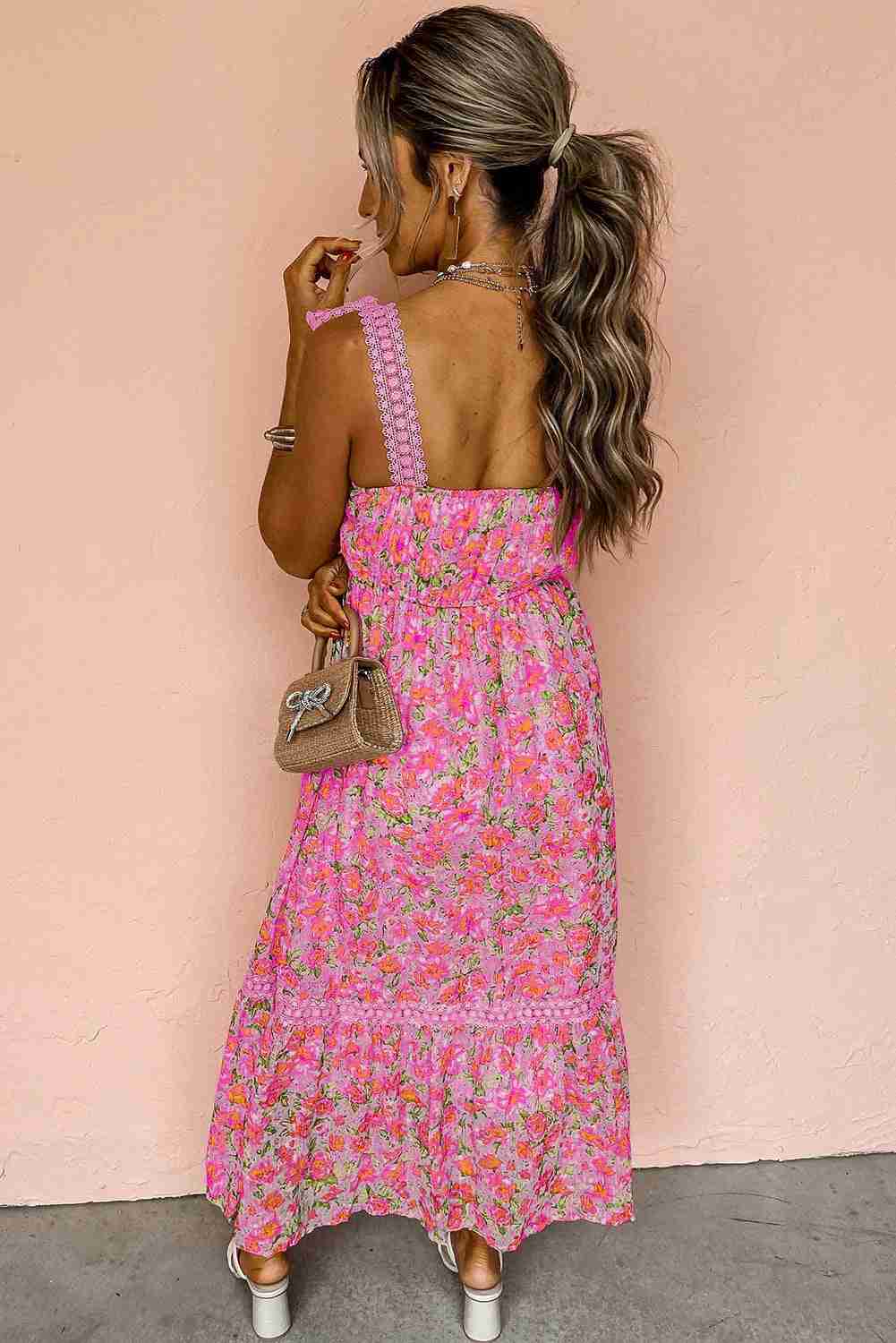 Robe longue rose à motif floral, dos avec bretelles festonnées et volants bas.