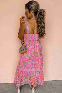 Robe longue rose à motif floral, dos avec bretelles festonnées et volants bas.
