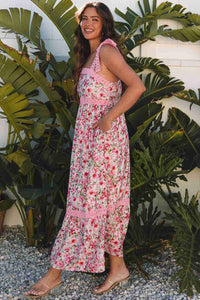 Robe longue rose à motif floral, bretelles festonnées et encolure carrée.