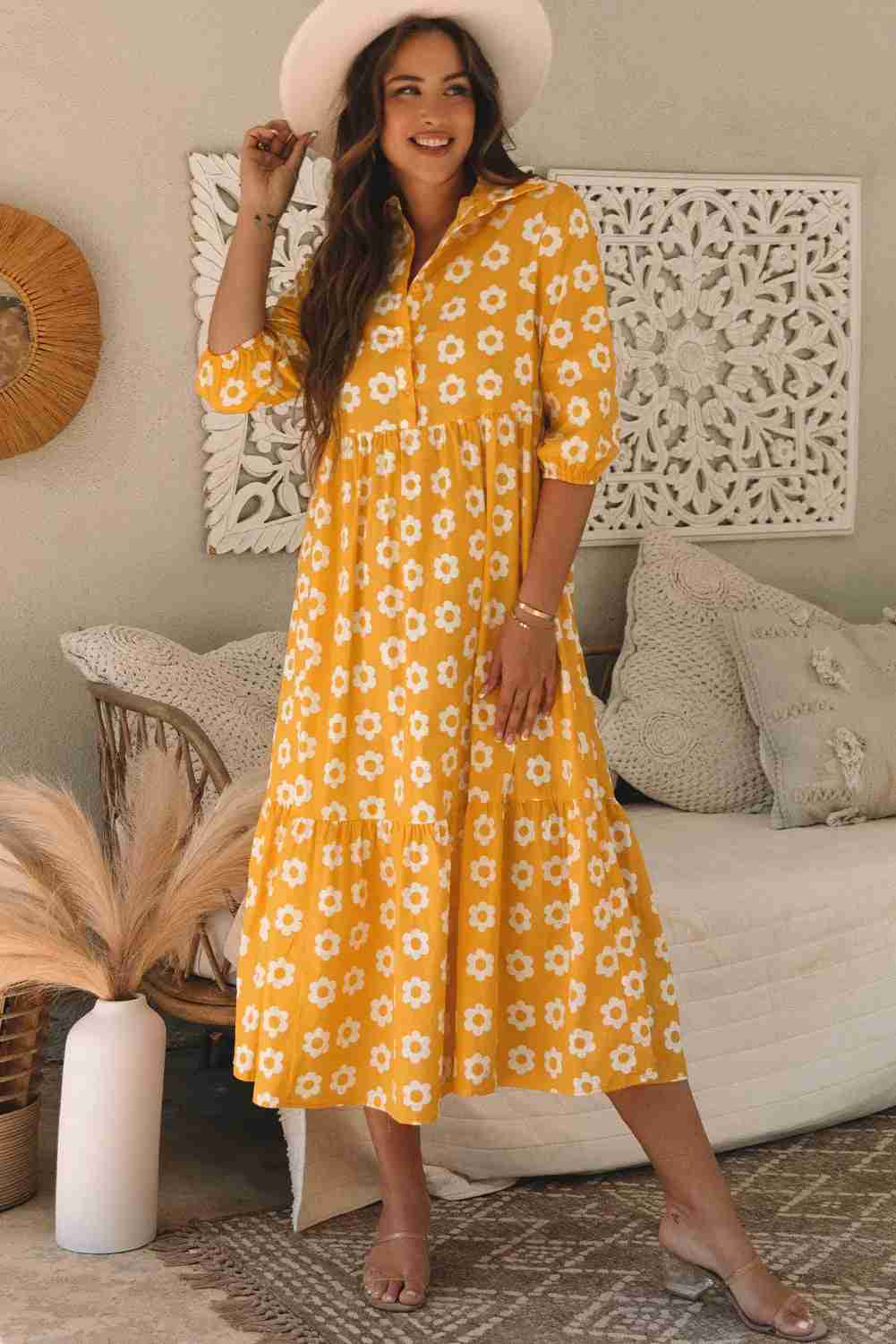 Robe maxi jaune à fleurs blanches, col chemisier et manches trois-quarts, boutons.