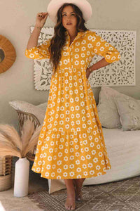 Robe maxi jaune à fleurs blanches, col chemisier, fermeture à boutons au buste, ample.