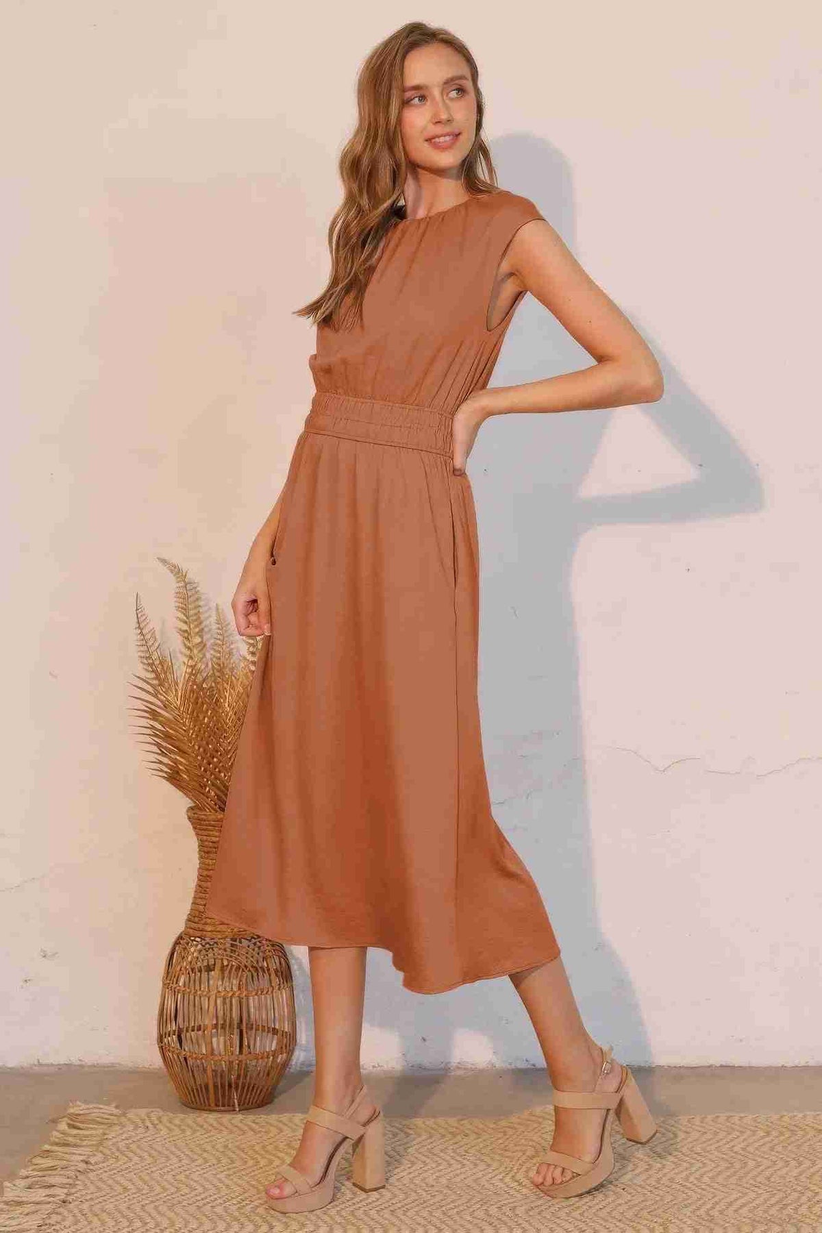 Robe midi café sans manches, ceinture froncée élastique, plis légers à la jupe.