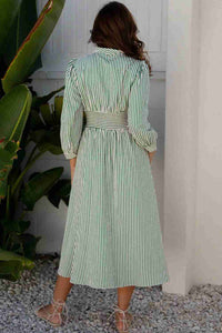 Robe midi rayée vert et blanc, vue de dos, taille haute ceinturée, manches 3/4.