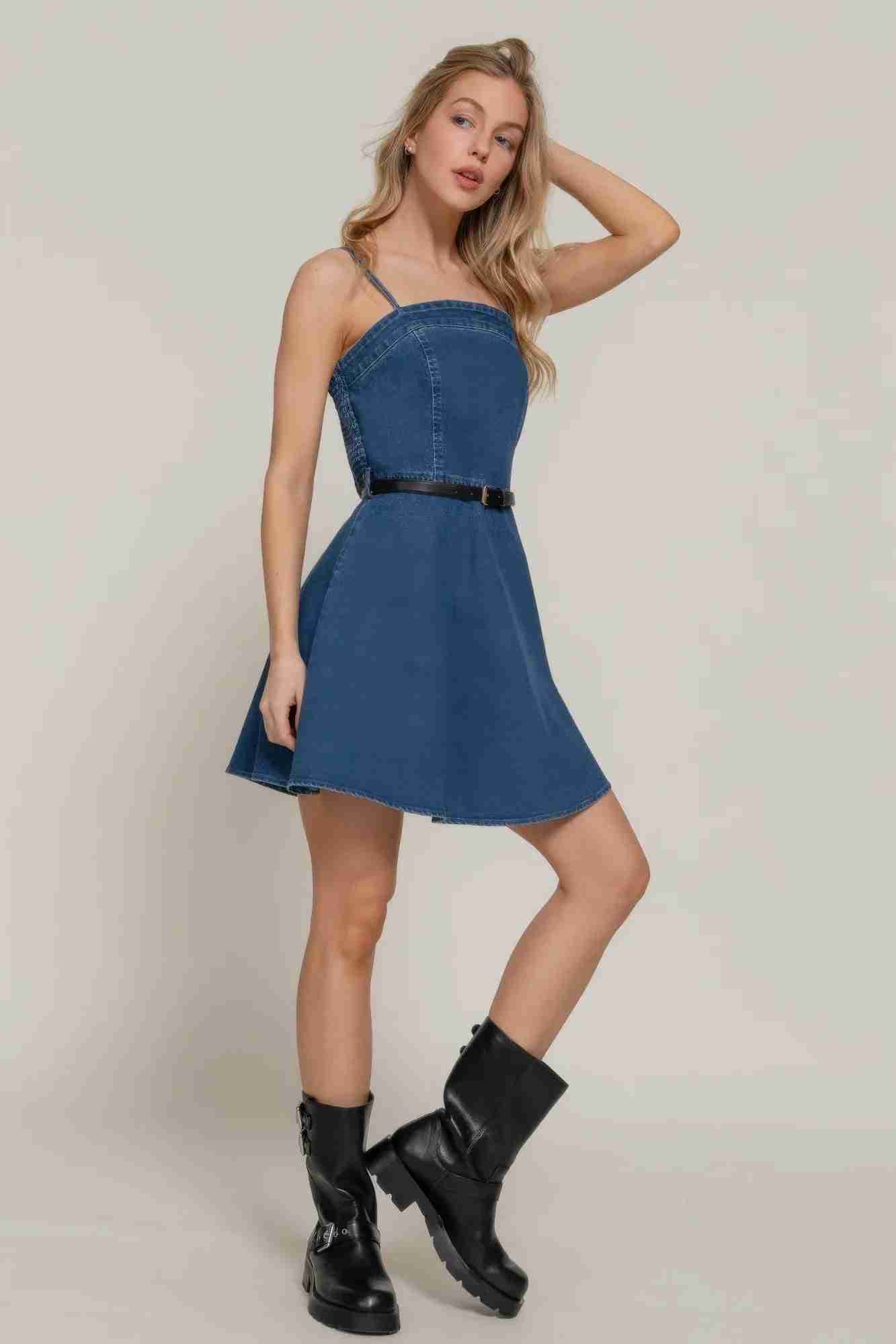 Robe courte en jean bleu foncé, bretelles spaghetti, ceinture à boucle, jupe évasée.