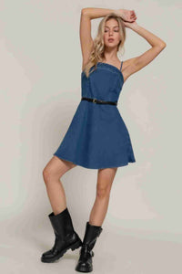 Robe mini en jean bleu foncé, bretelles fines, ceinture noire à boucle, jupe évasée.
