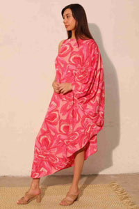 Robe fluide rose imprimé floral, dos nu et manche drapée, coupe midi