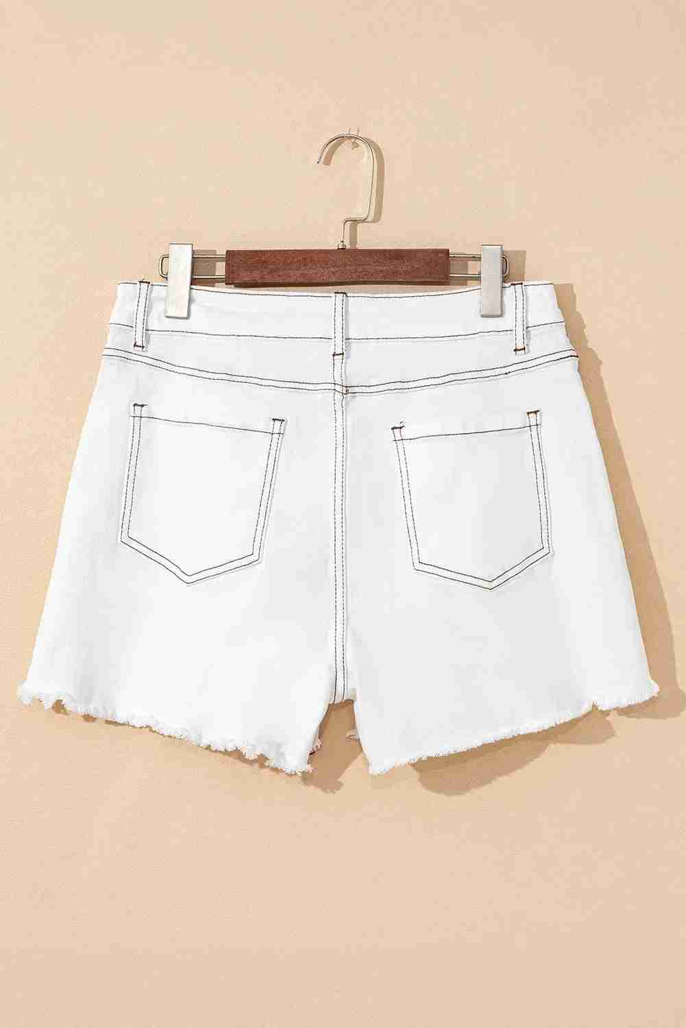 Short en jean blanc taille haute avec poches avant contrastées, fermeture à bouton, ourlet effiloché.