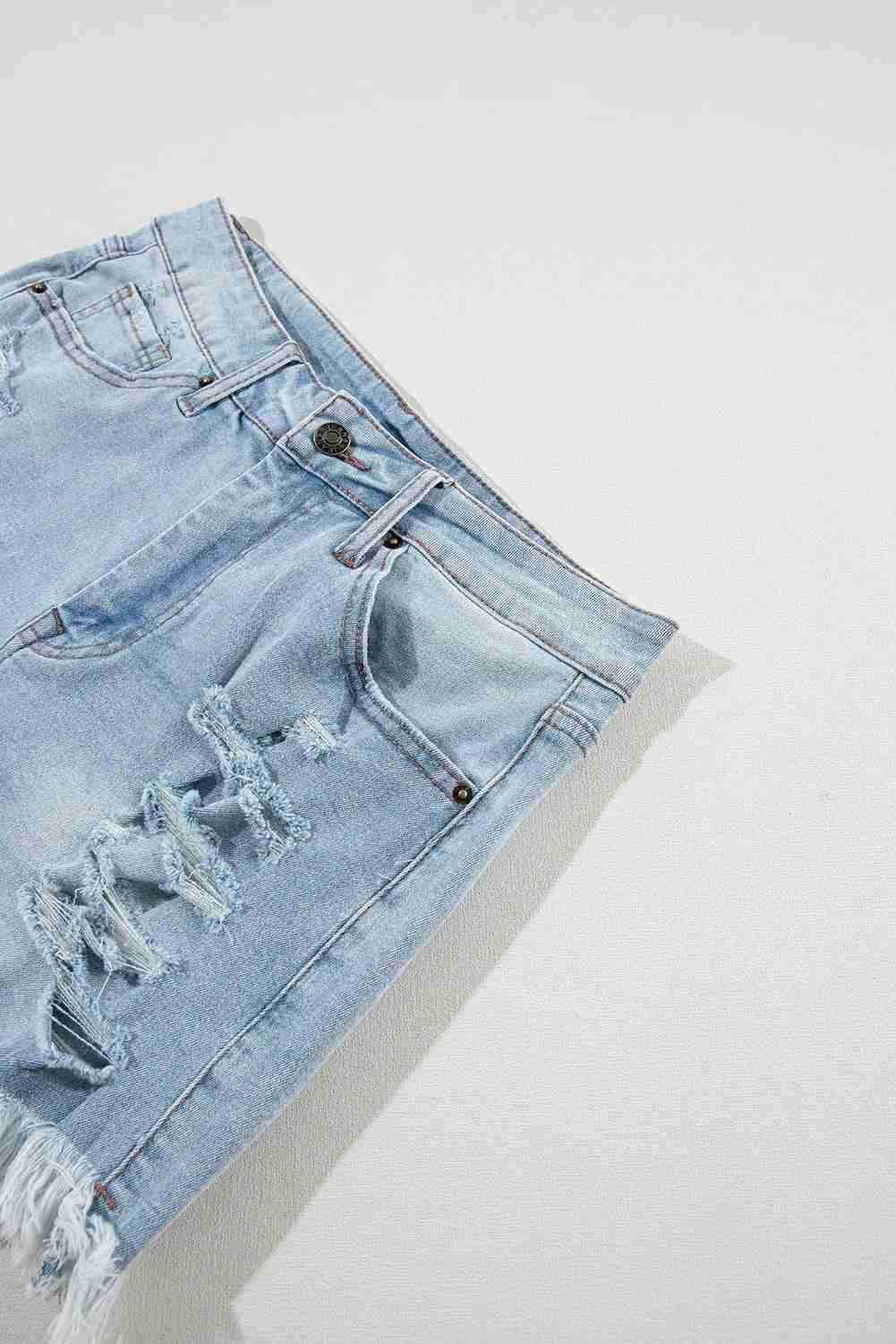 Short en jean bleu clair taille haute déchiré, braguette et surpiqûres, ourlet effiloché