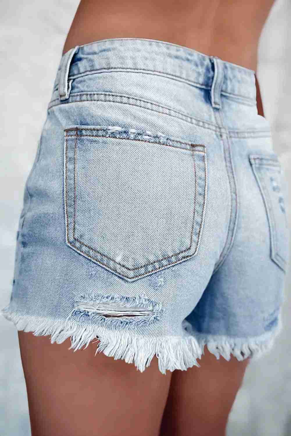 Short en jean bleu clair taille haute, poche arrière, couture latérale et bords effilochés
