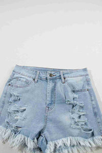 Short en jean bleu clair taille haute, déchirures devant, ourlet effiloché et poches visibles