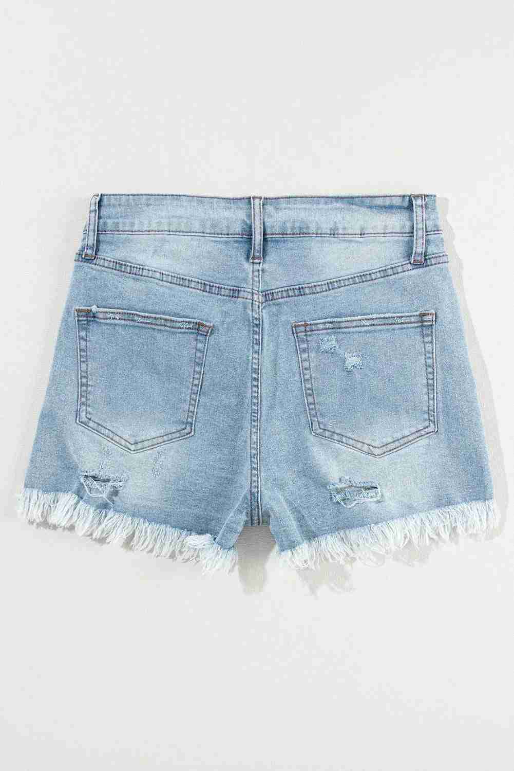 Short en jean bleu clair taille haute, poches arrière, bas effilochés et déchirures discrètes