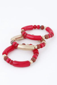 Bracelet de perles rouges et beige, perles dorées, doubles tours visibles.
